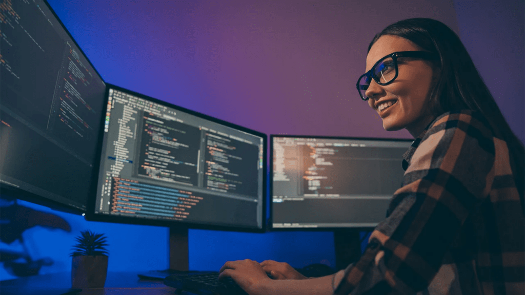 Game designer analyzing complex gameplay systems and code across multiple monitors